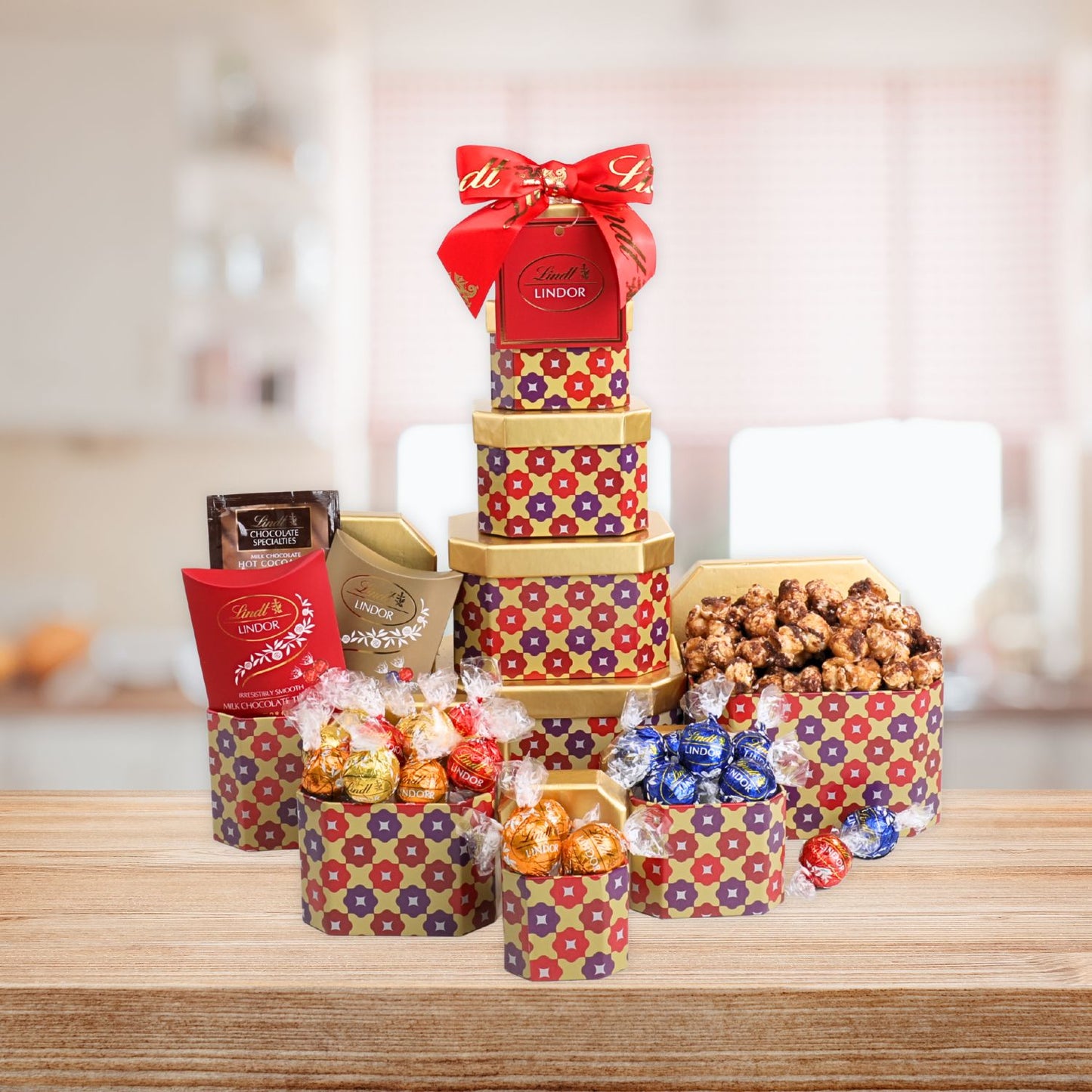 Decorative gift tower with Lindor truffles and other confections on a wooden surface.