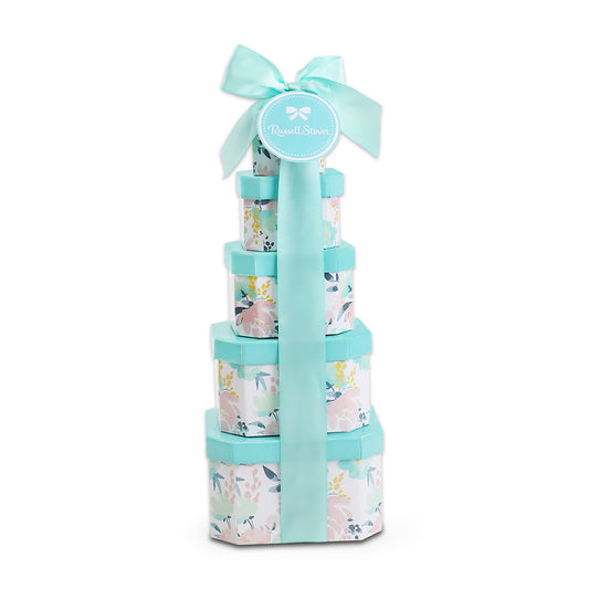 Stack of floral-patterned gift boxes tied with a blue ribbon on a white background