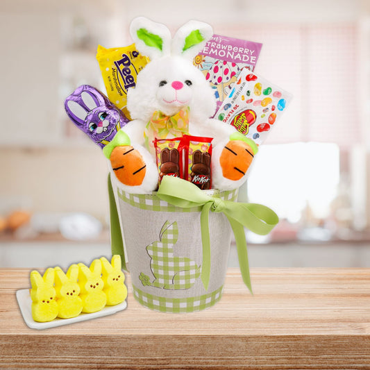 Easter gift basket with plush bunny, candy, and snacks on a wooden table.