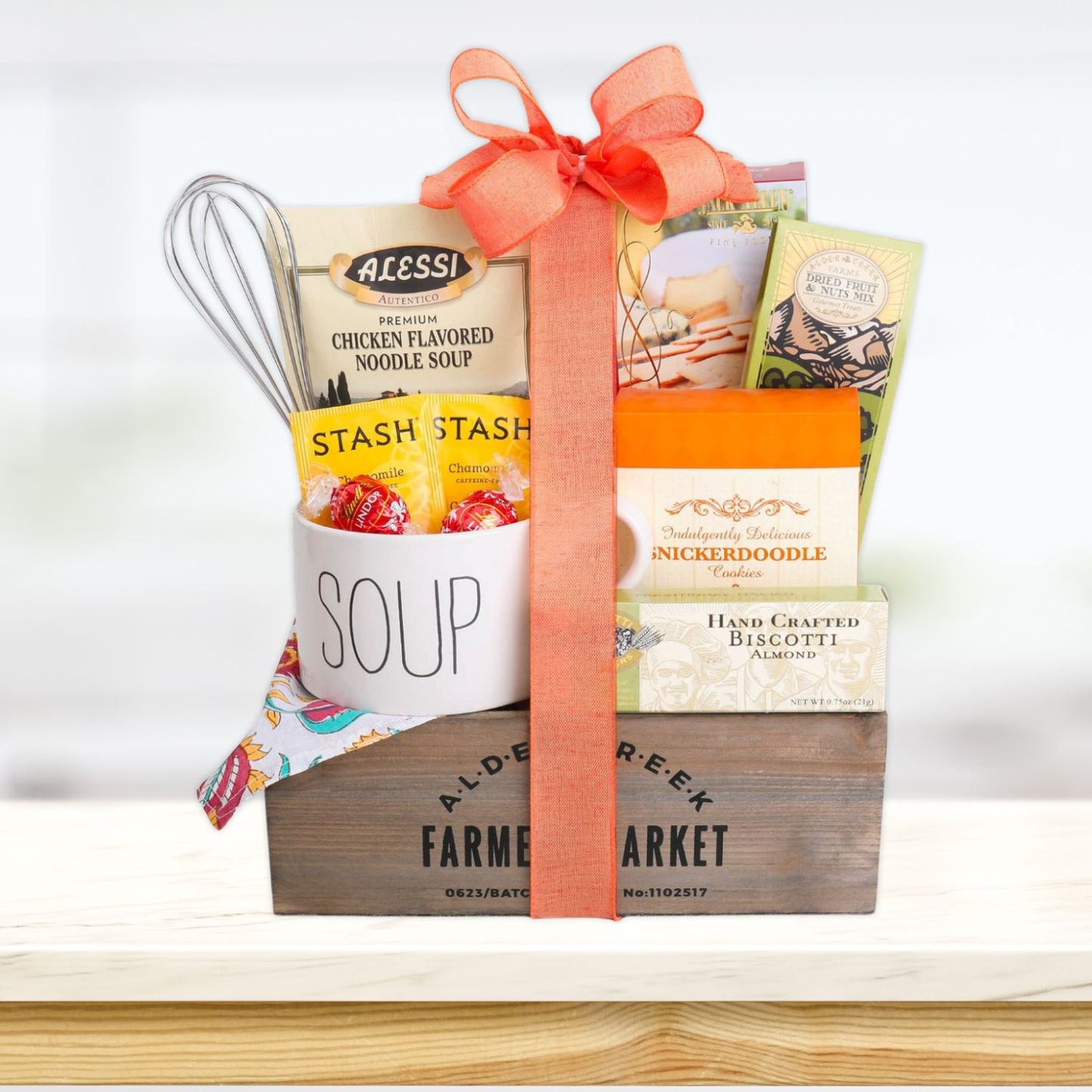 Gift basket with soup ingredients and a wooden crate on a white background
