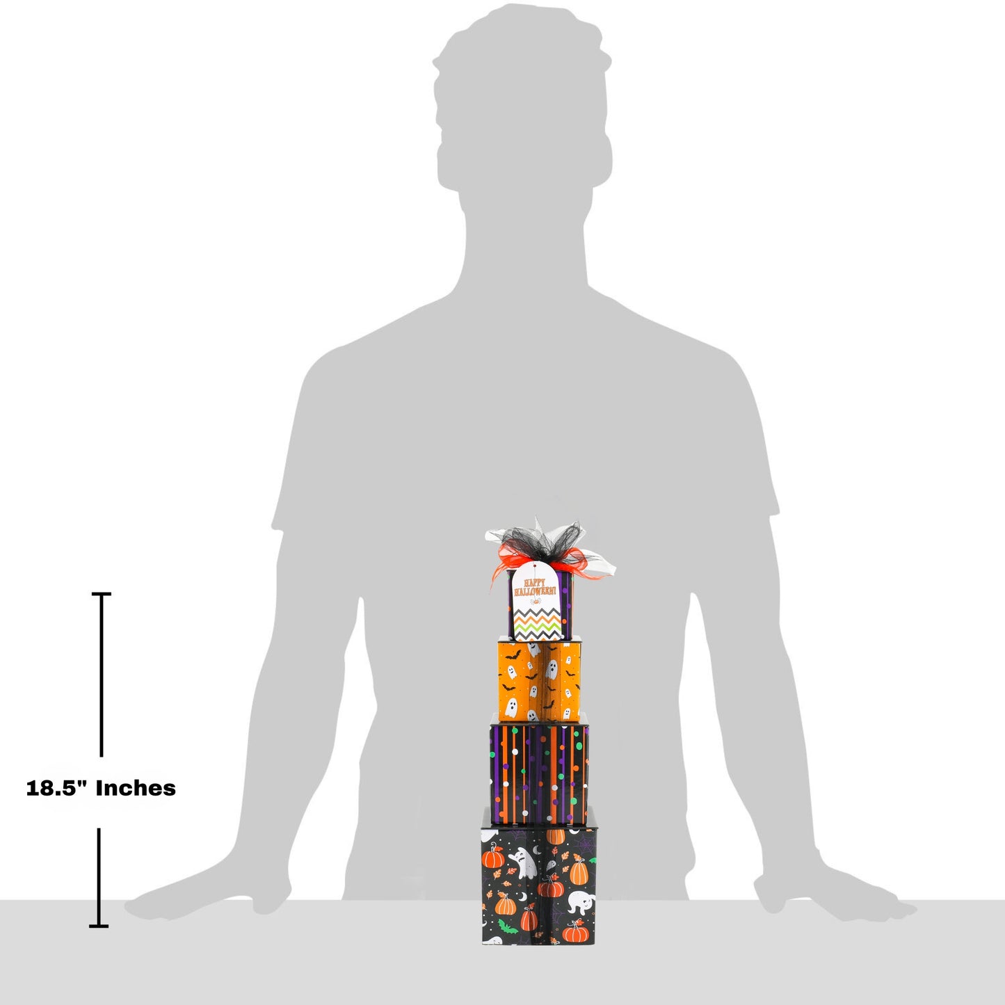 A small Halloween-themed gift tower display stands in front of a large gray human silhouette on a white background, with a vertical measurement marker reading 18.5 inches.