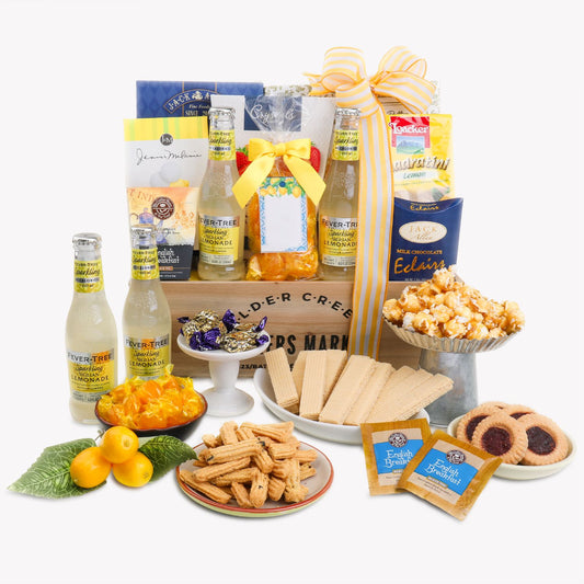 Gourmet gift basket with lemonade, snacks, and treats on a white background