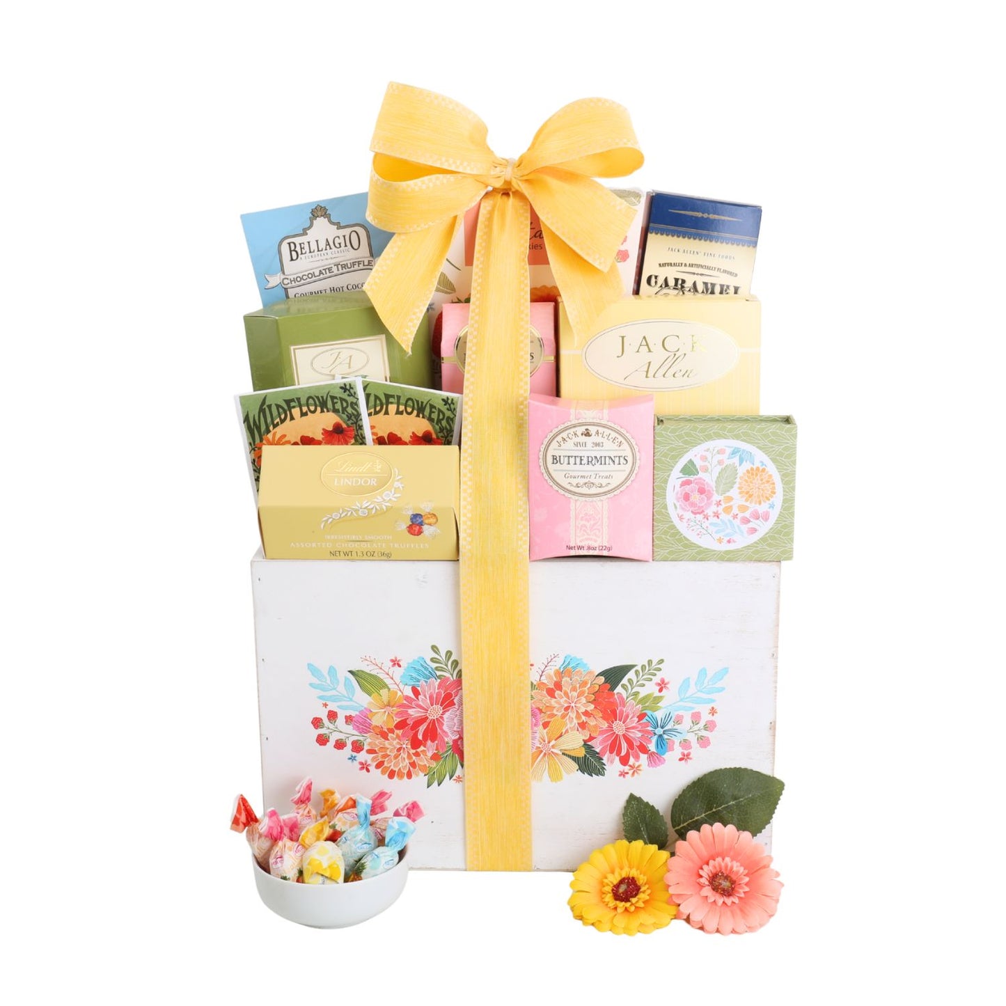 Gift basket with a yellow ribbon, flowers, and various items on a white background