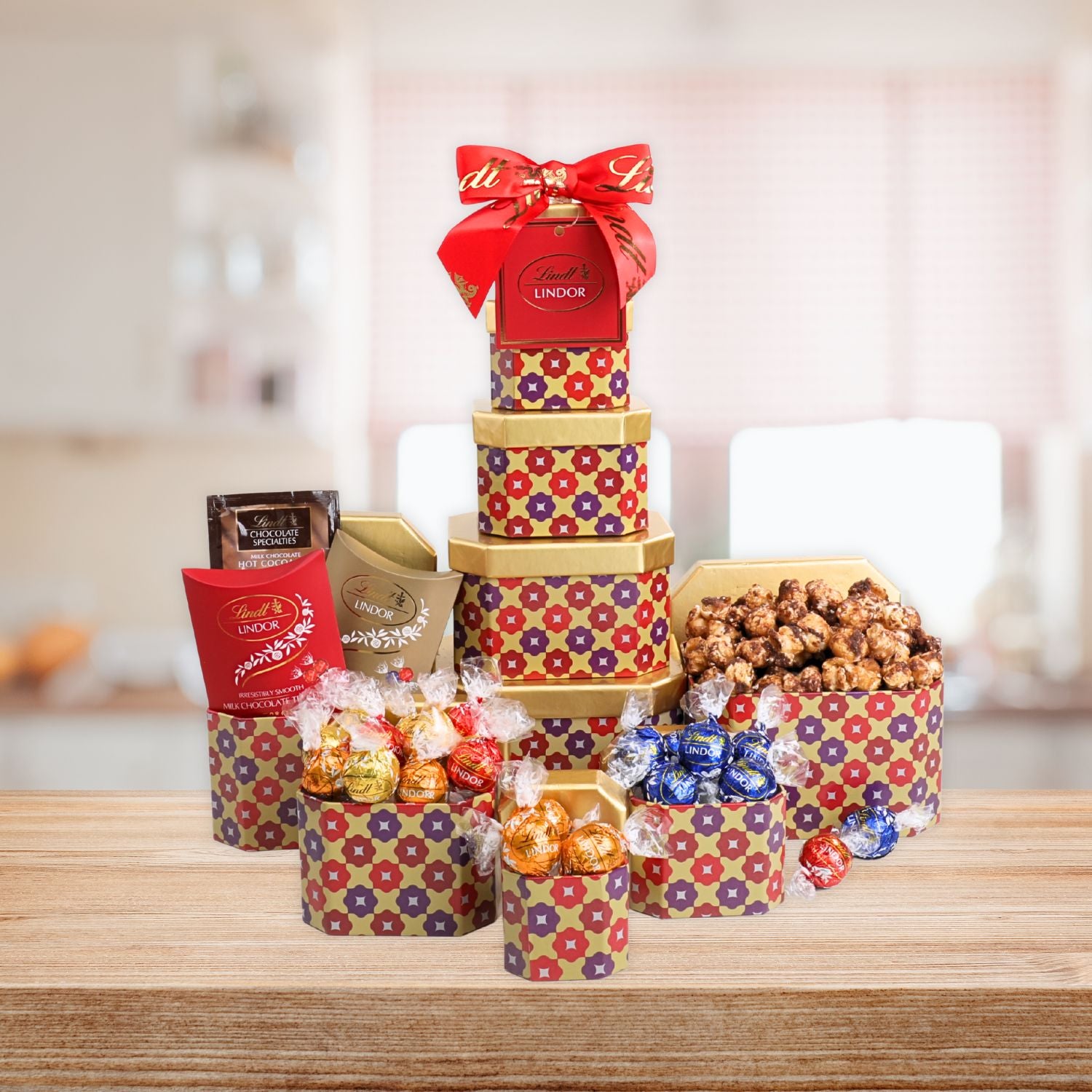 Decorative gift tower with Lindor truffles and other confections on a wooden surface.