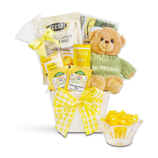 Gift basket with teddy bear, tea packages, and candy on a white background