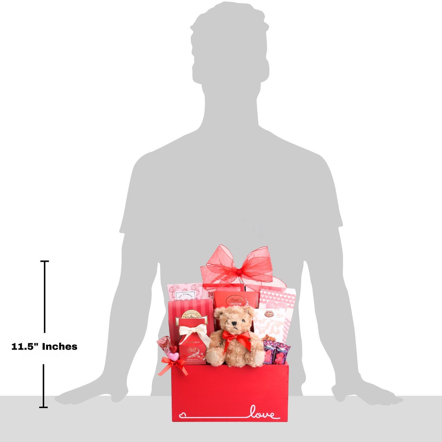 Gift basket with a teddy bear and other items, shown with a silhouette of a person for scale.