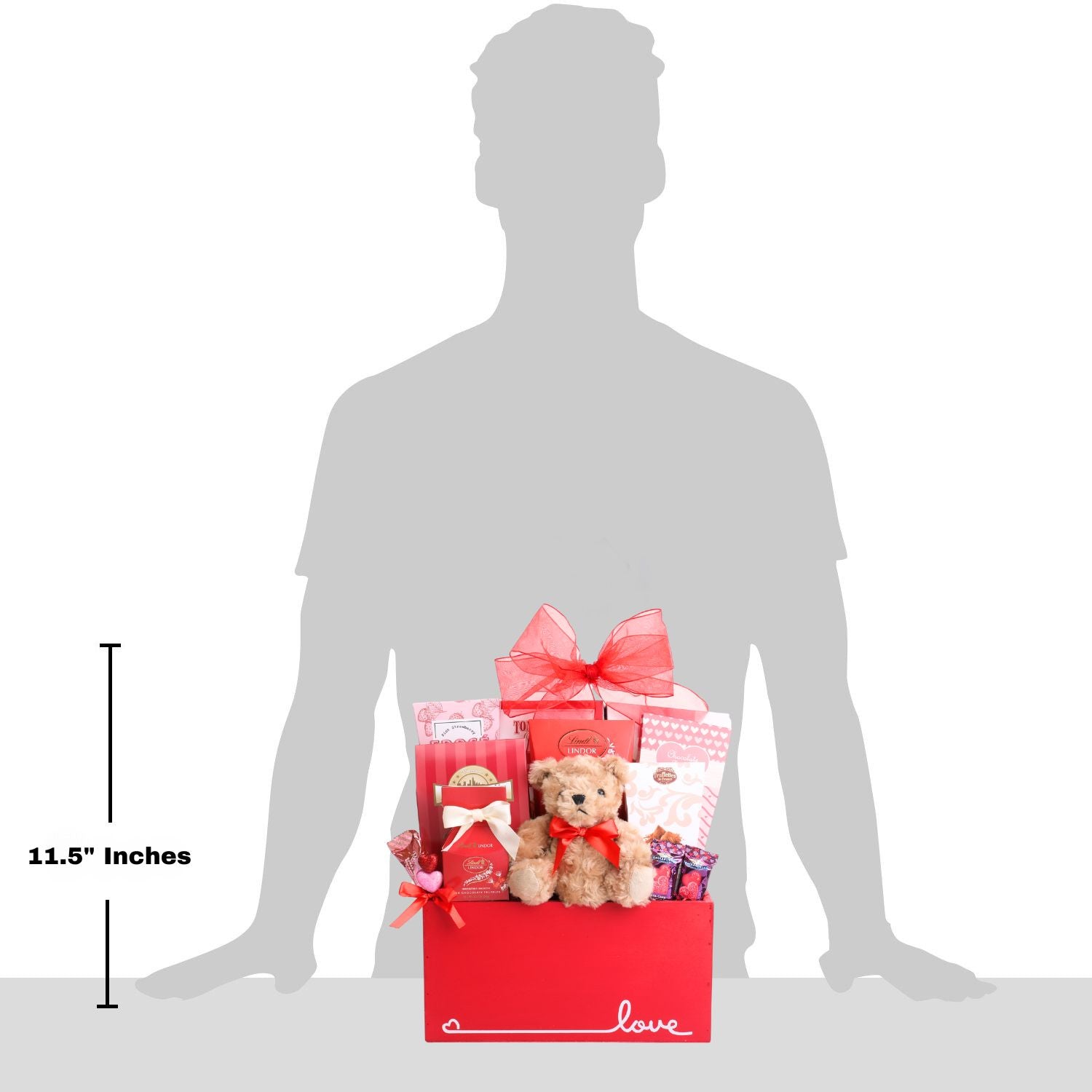 Gift basket with a teddy bear and other items, shown with a silhouette of a person for scale.