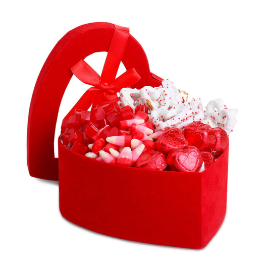 Red heart-shaped basket filled with Valentine's Day-themed candies on a white background