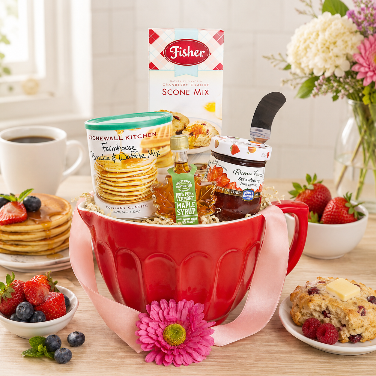Redmixing bowl filled with baking items on a table with breakfast foods.