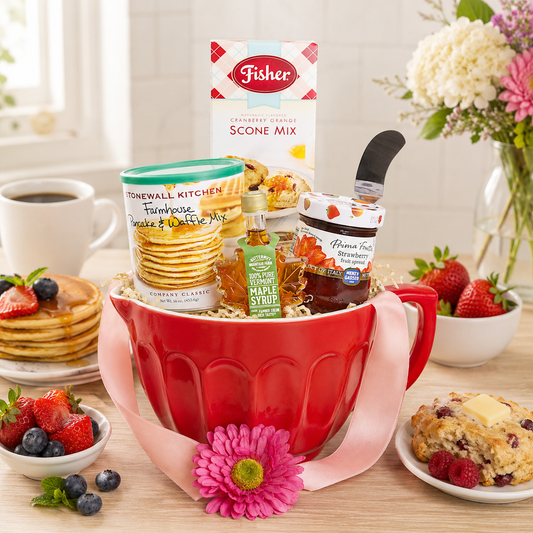 Redmixing bowl filled with baking items on a table with breakfast foods.