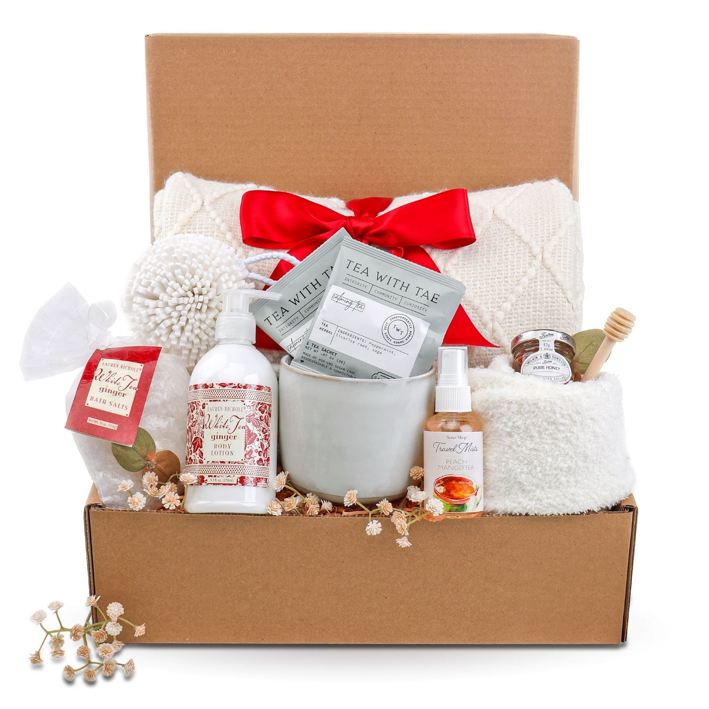 Gift basket with a red bow, including a mug, tea bags, and other items on a white background