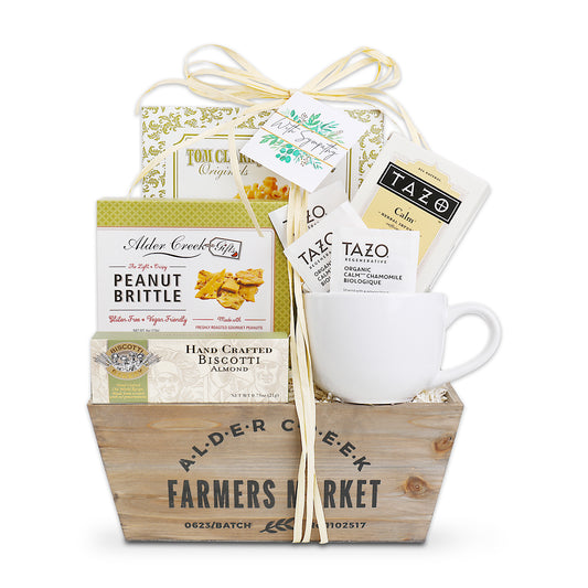 Gift basket with a mug, snacks, and tea packages on a white background
