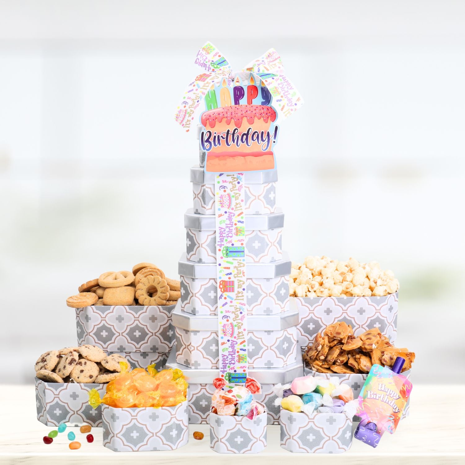 Gift tower with snacks and a 'Happy Birthday!' card on a white background