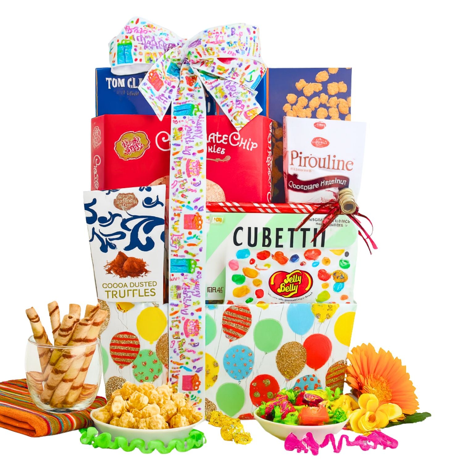 Assorted candy and snack items displayed in front of gift basket on white background