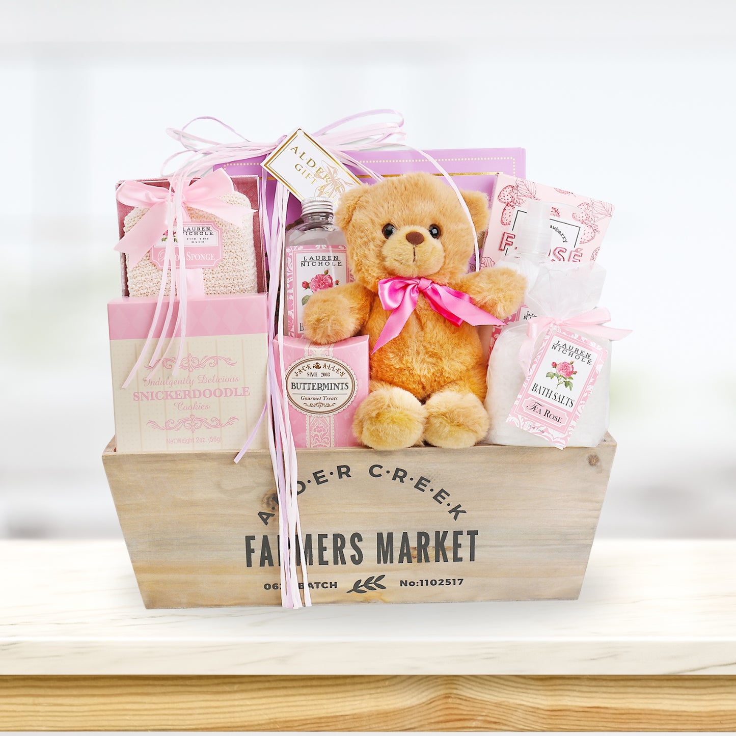 Gift basket with teddy bear, bath products, and other items on a white background