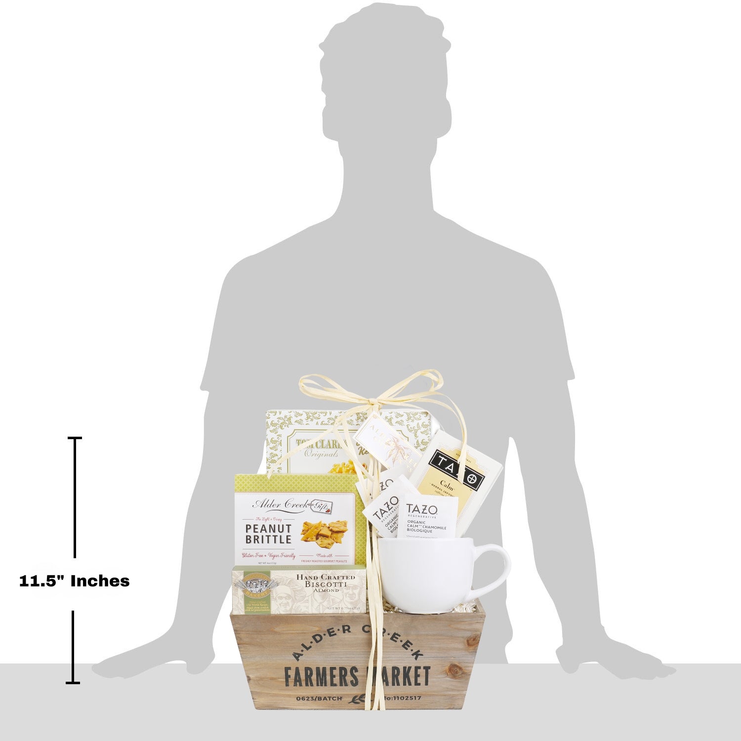 Gift basket with tea set and snacks shown next to a silhouette of a person for size reference.