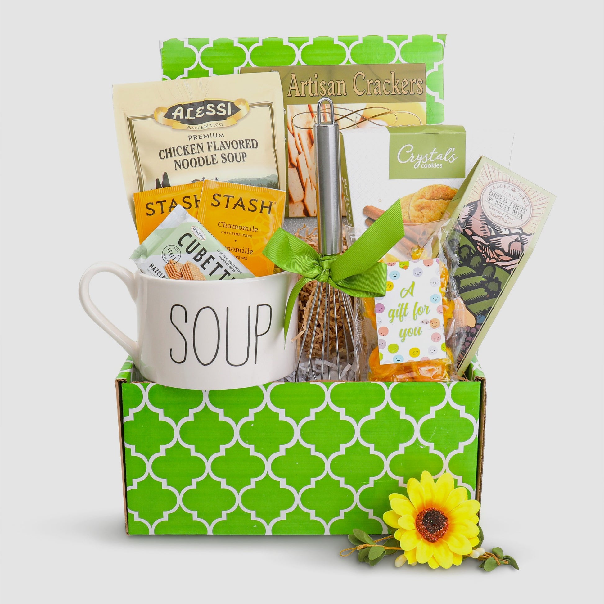 Gift basket with a 'SOUP' mug, snacks, and a sunflower on a white background