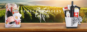 Two wine gift baskets on image of vineyard with Temecula Valley Gift Co. logo with bow